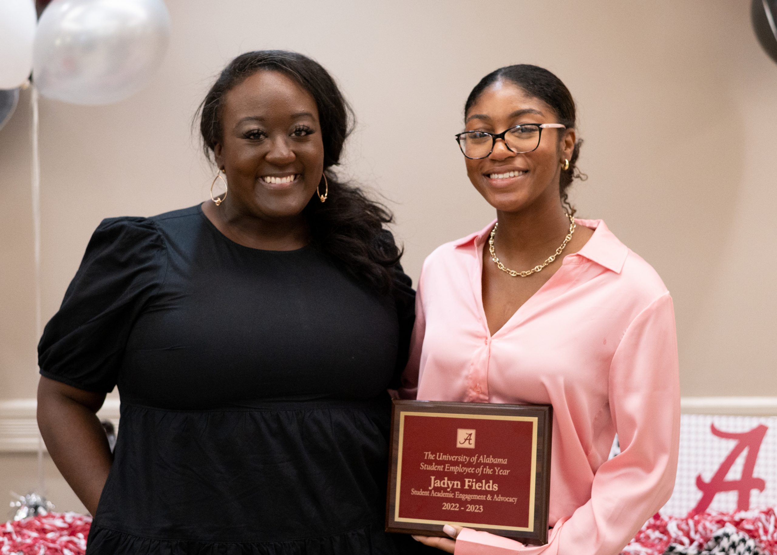 Jadyn Fields holding her plaque while standing with her supervisor